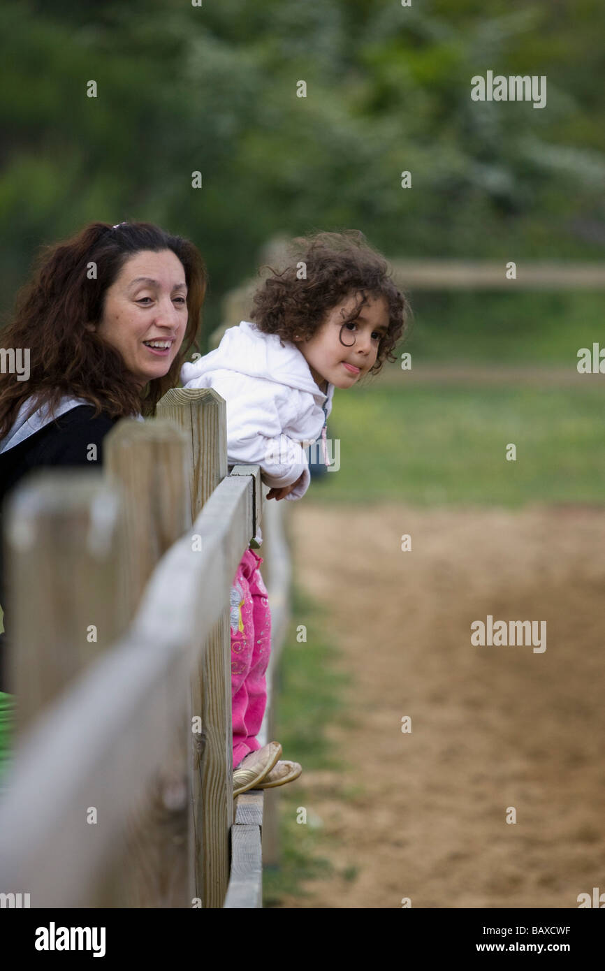 La madre e il bambino sono wathing horseriders da recinzione Foto Stock