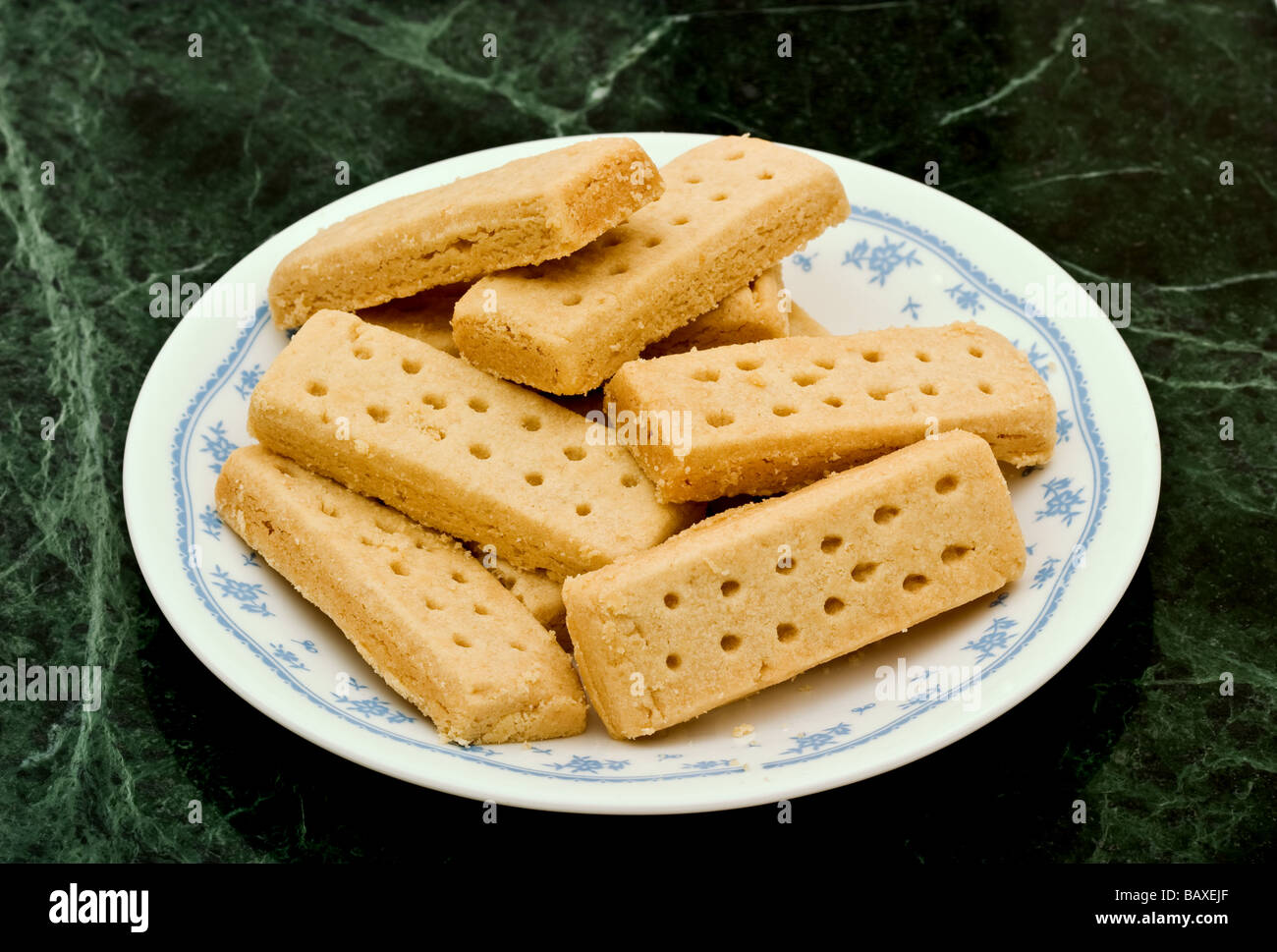 Una pila di biscotti frollini dito su un bianco lastra decorata Foto Stock