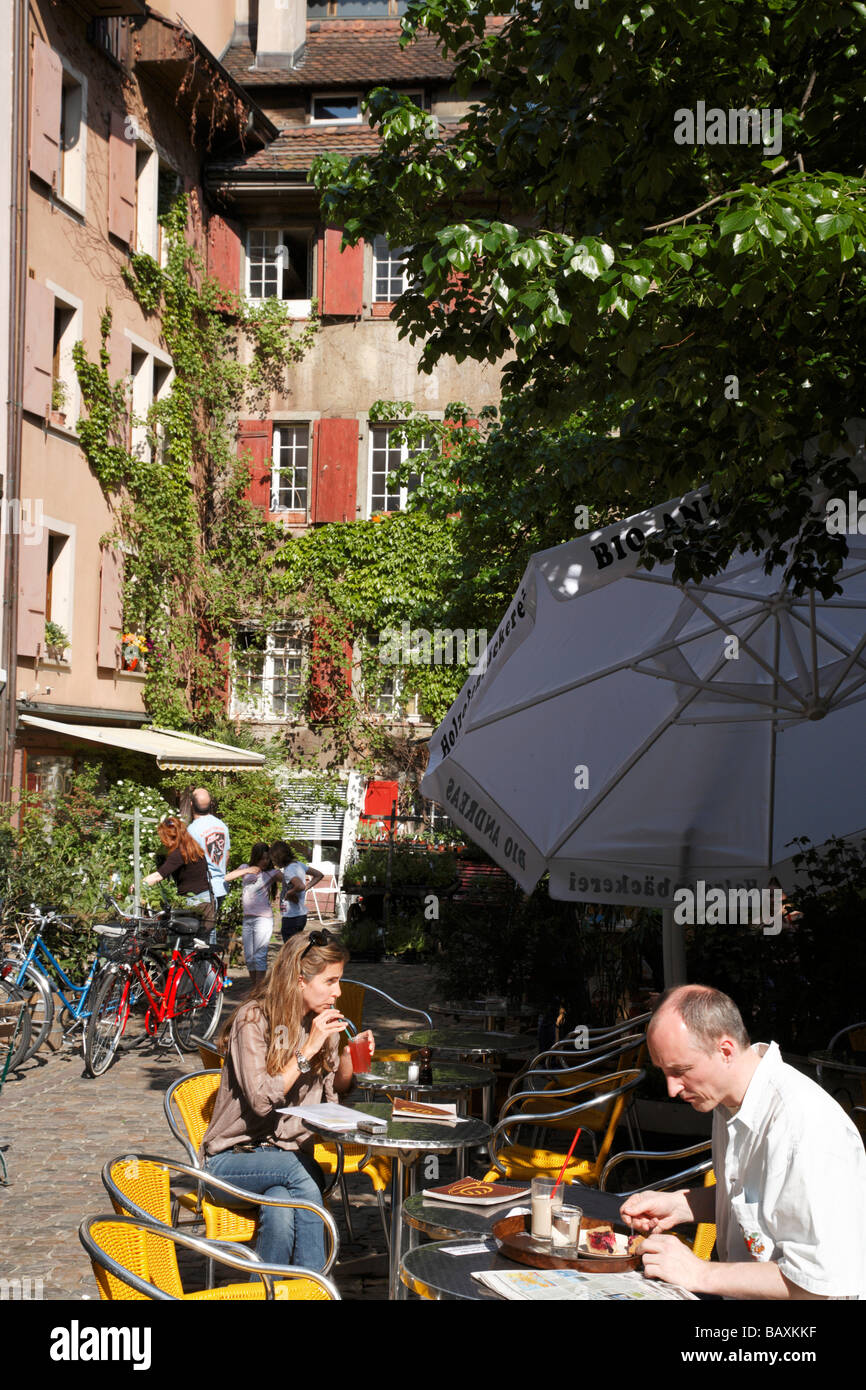 La gente seduta in una caffetteria al Andreasplatz, Basilea, Svizzera Foto Stock