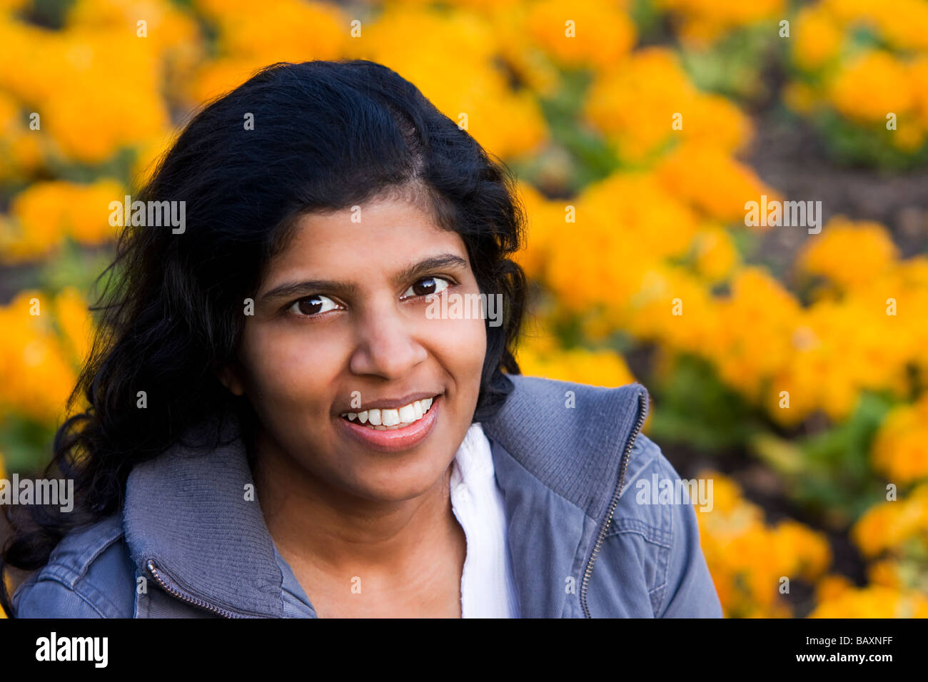 Giovane donna contro un fiore giallo sullo sfondo Foto Stock