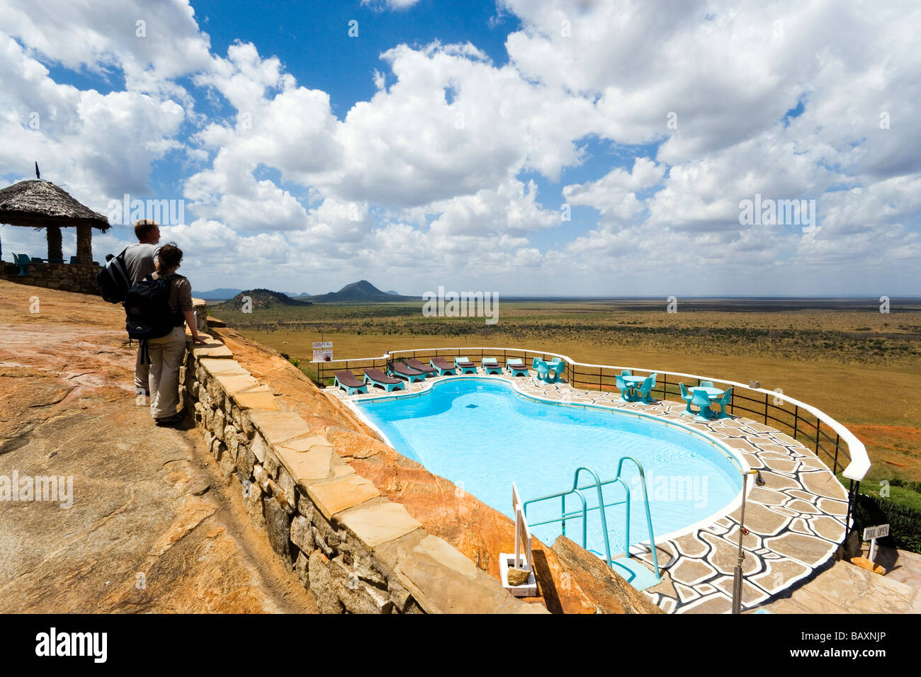 Gli ospiti che sono alla ricerca sulla piscina a Savannah, Voi Safari Lodge, parco nazionale orientale di Tsavo, costa, Kenya Foto Stock