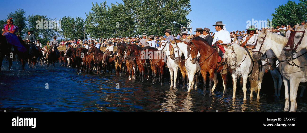 Pellegrini a cavallo in piedi nel fiume, Andalusia, Spagna Foto Stock