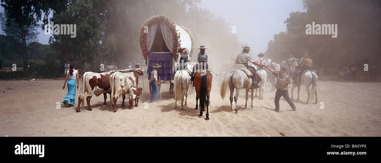 I pellegrini in viaggio a piedi, a cavallo e con carri trainati da buoi sulla sabbiosa Raya Real, Andalusia, Spagna Foto Stock