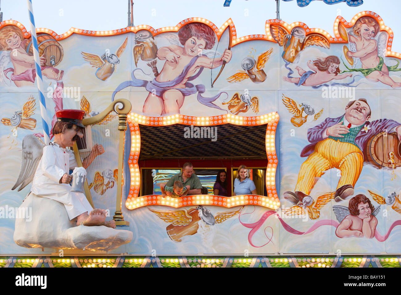 Le persone che guardano da una finestra della galleria speculare al Oktoberfest Monaco di Baviera, Germania Foto Stock