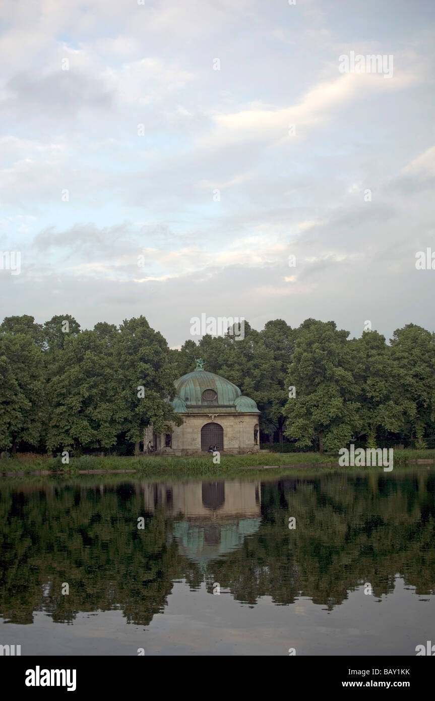 Le acque del canale di Nymphenburg reflekting situato in un edificio storico e alcuni alberi, Monaco di Baviera, Germania Foto Stock