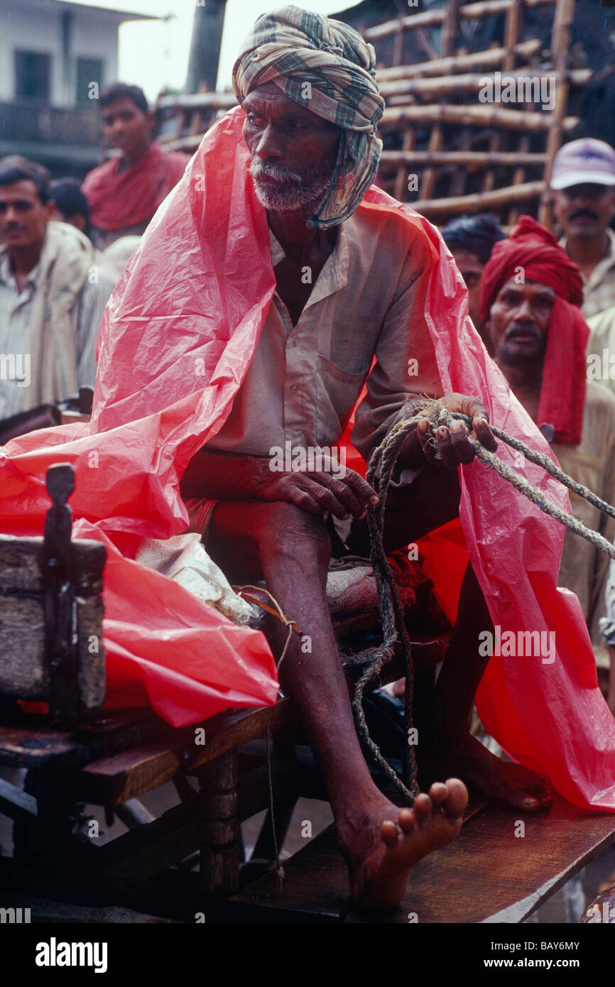 Cocchiere, telone in materiale plastico, il monsone, nei pressi di Muzaffarpur, Bihar, in India Foto Stock