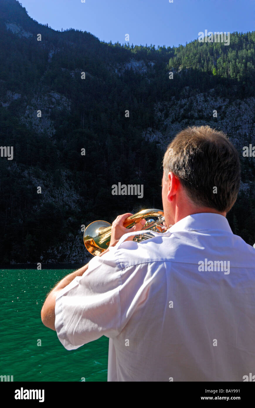 L'uomo gioca flicorno, echo al lago Koenigssee, gamma di Berchtesgaden, Parco Nazionale di Berchtesgaden Berchtesgaden, Alta Baviera, Foto Stock