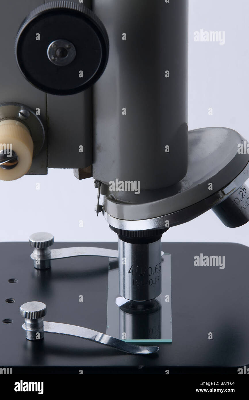 Vista laterale di un microscopio tradizionale, mostra fine corso e manopole di messa a fuoco, lo stadio e la diapositiva campione. Foto Stock