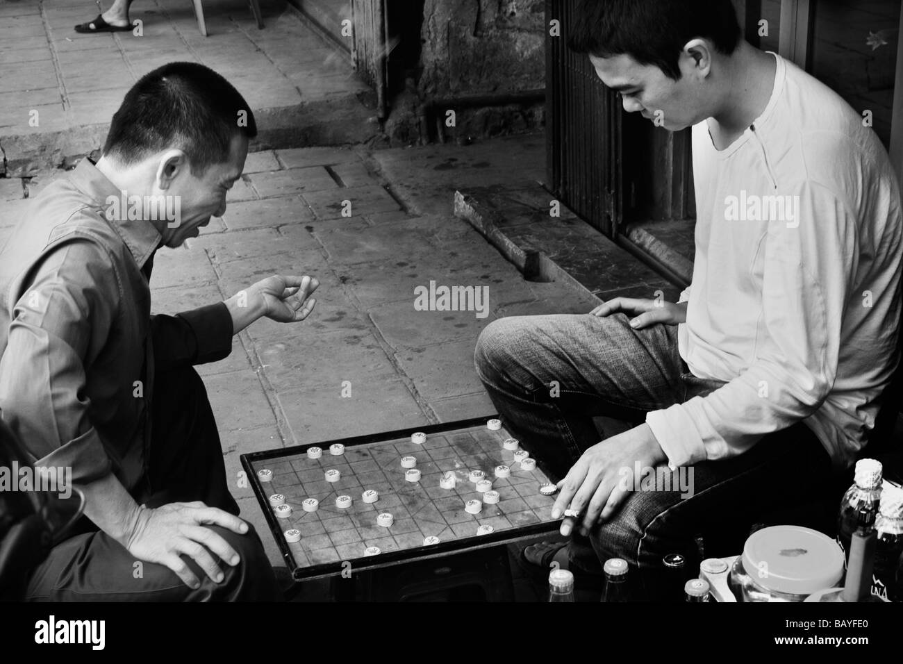Due uomini giocano xiangqi sulle strade del quartiere vecchio, Hanoi, Repubblica Socialista del Vietnam. Foto Stock