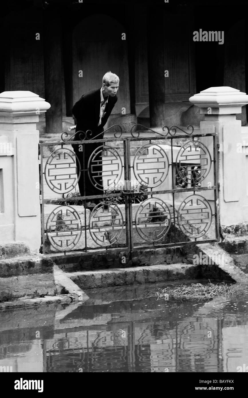 Un uomo guarda nel pozzo celeste della chiarezza presso il Tempio della Letteratura ad Hanoi, Repubblica Socialista del Vietnam. Foto Stock