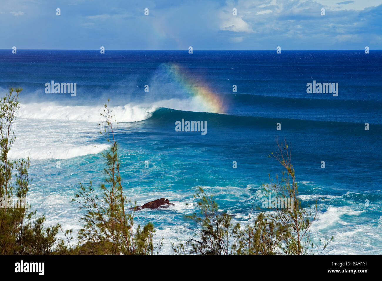 Un arcobaleno forme off spin deriva da una grande onda a Maui North Shore, Hawaii. Foto Stock