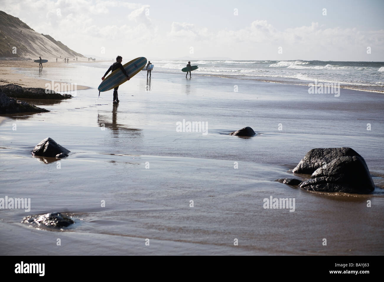 Surfers su una spiaggia Foto Stock