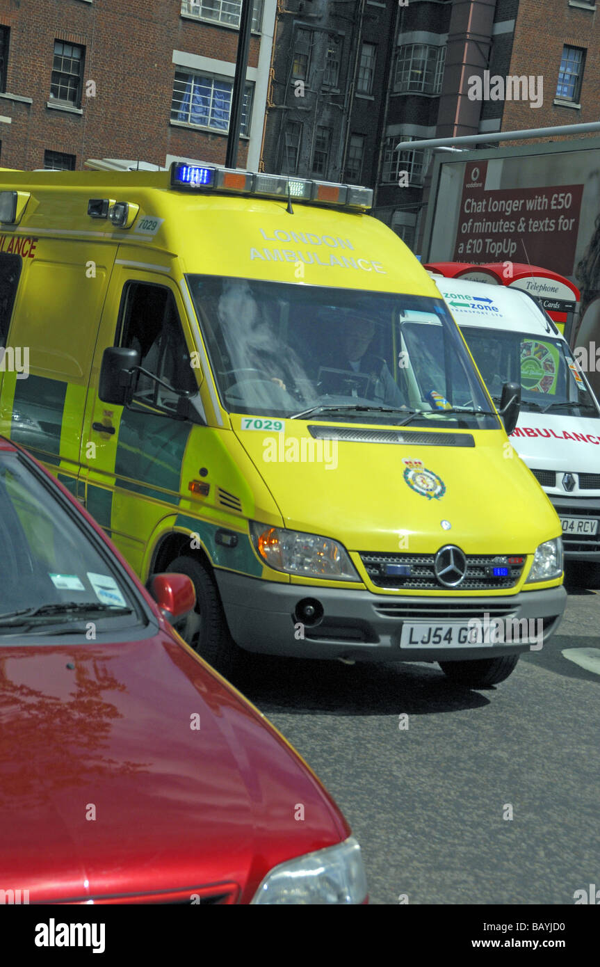 London Ambulanza con luci blu lampeggiante sul modo in caso di emergenza e bloccato nel traffico England Regno Unito Foto Stock
