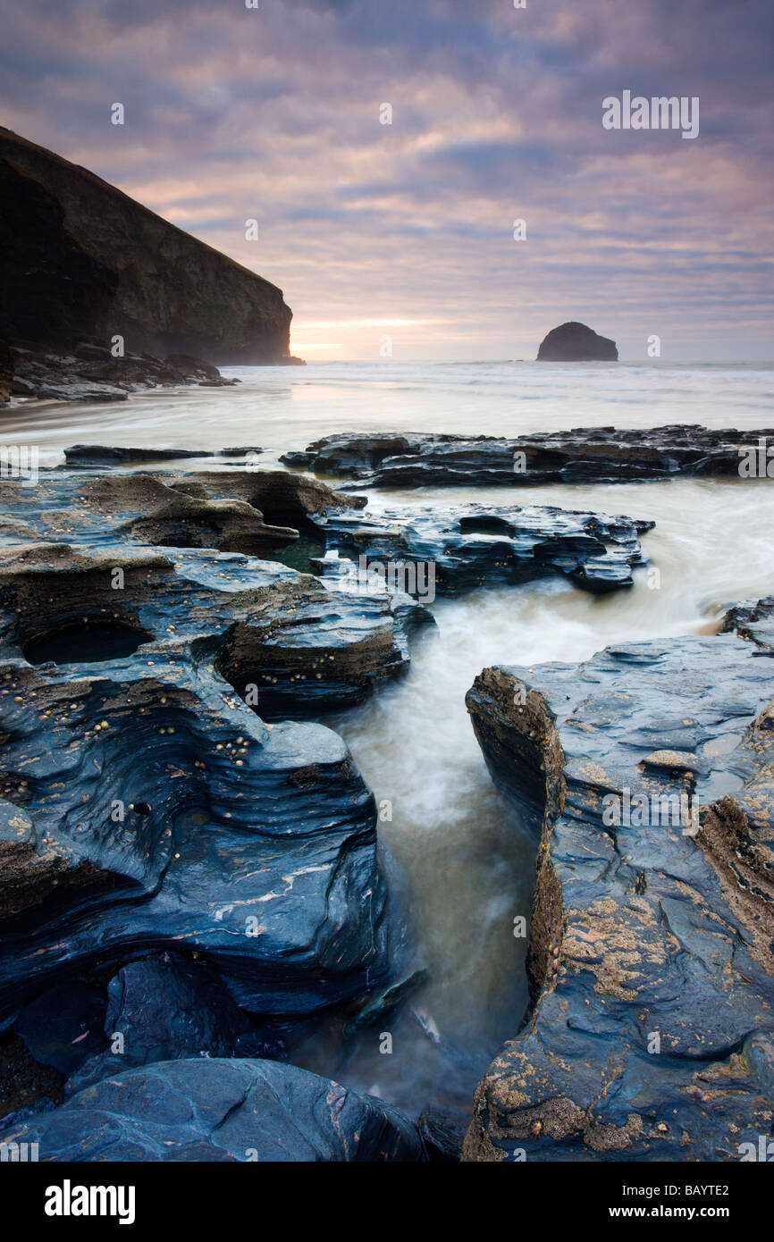 Ardesia erose rocce sulla spiaggia a Trebarwith Strand guardando verso Gull Rock Cornwall Inghilterra Febbraio 2009 Foto Stock