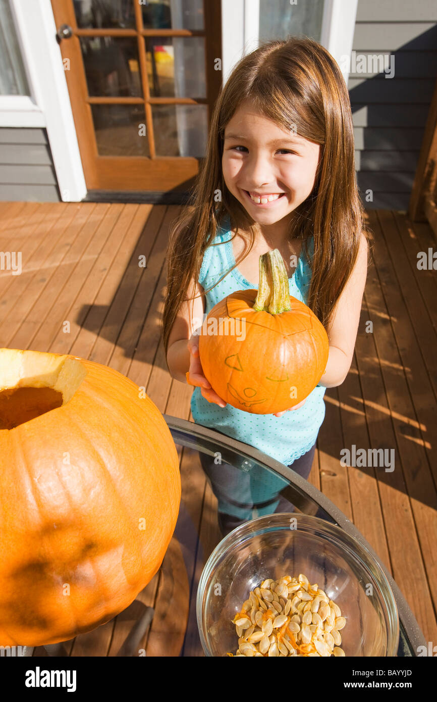 Razza mista ragazza giovane azienda zucca di Halloween Foto Stock