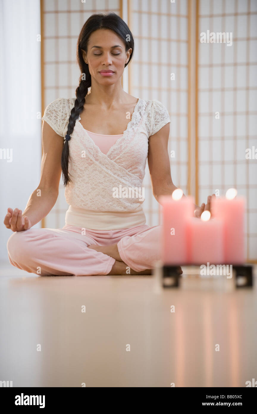 Razza mista donna meditando in lotus pongono Foto Stock