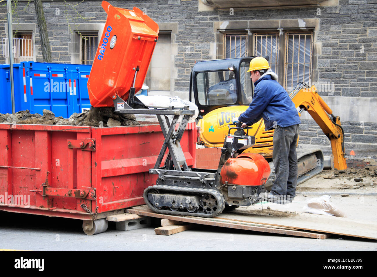 Una carriola motorizzata (mini trattore) e builder lavorando sulle strade di New York City. Foto Stock