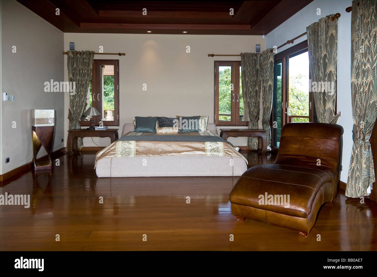Lussuosa camera da letto tropicale con pavimento in teak lucido e interni  asiatici moderni. Thailandia S. E. Asia Foto stock - Alamy