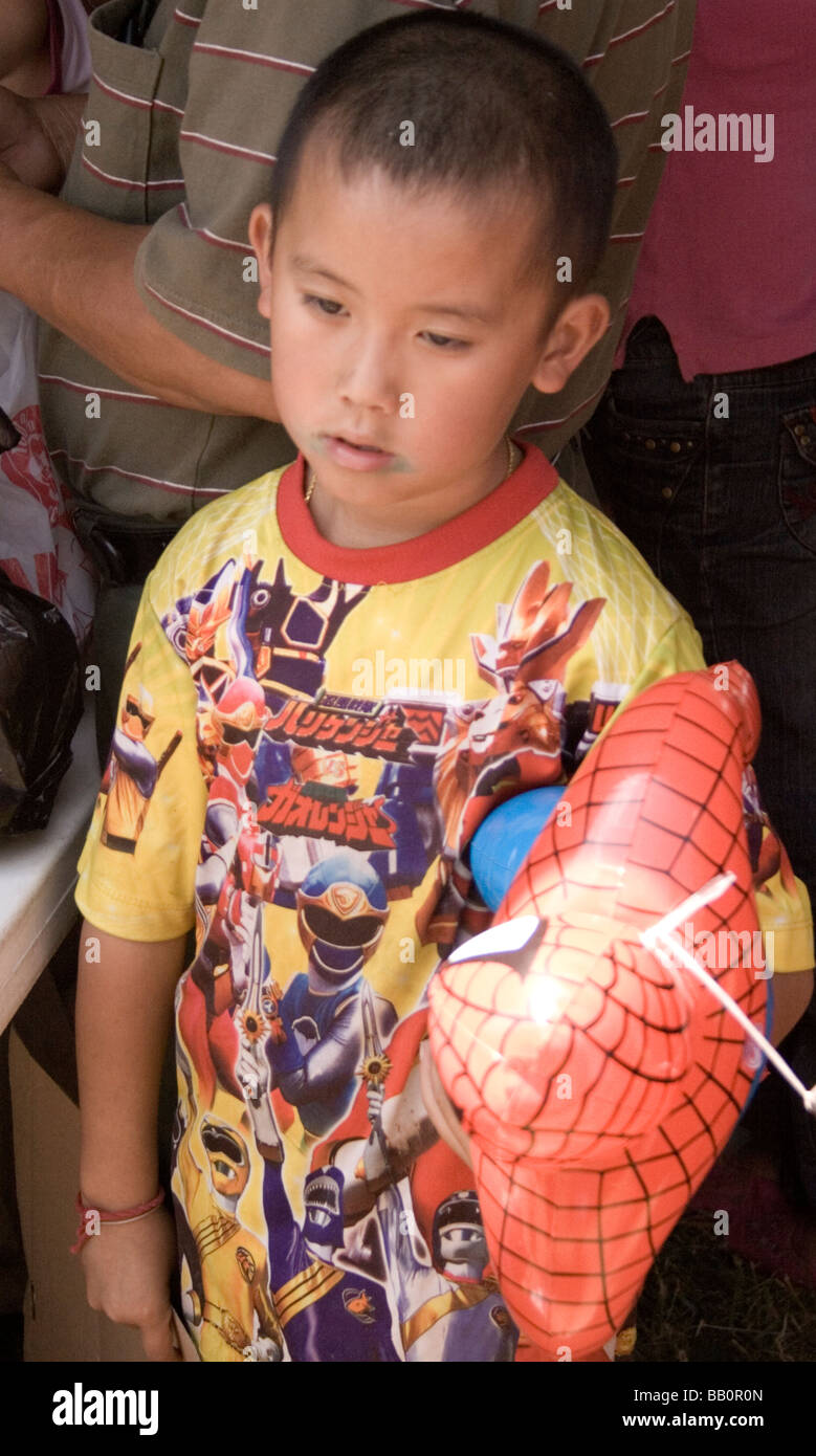 Giovane ragazzo Hmong che trasportano Spiderman palloncino. Hmong Sports Festival McMurray campo St Paul Minnesota USA Foto Stock