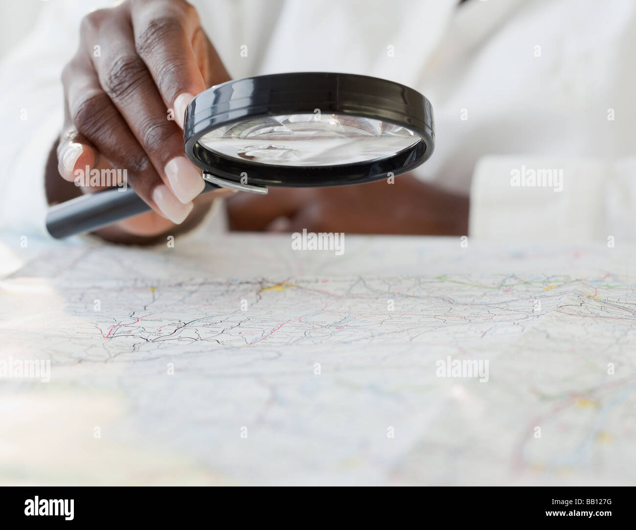 Donna africana con lente di ingrandimento sulla mappa Foto Stock