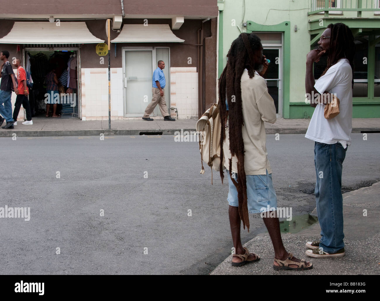 2 (due) uomini neri con dreadlocks casualmente a parlare su un angolo di strada nella regione dei Caraibi Foto Stock