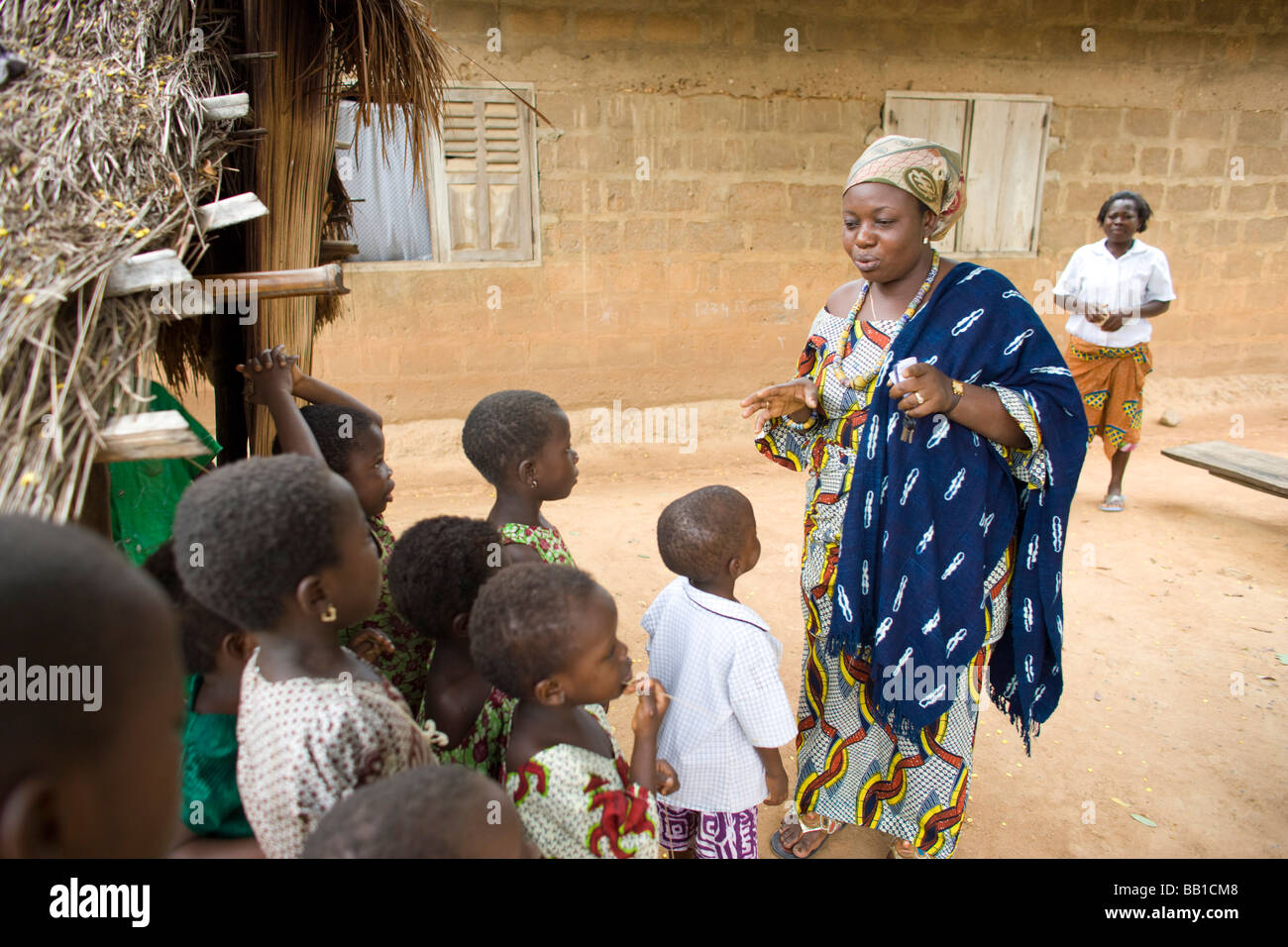 Donna, leader della comunità con il gruppo dei bambini, hanno, Ghana, Africa. Foto Stock