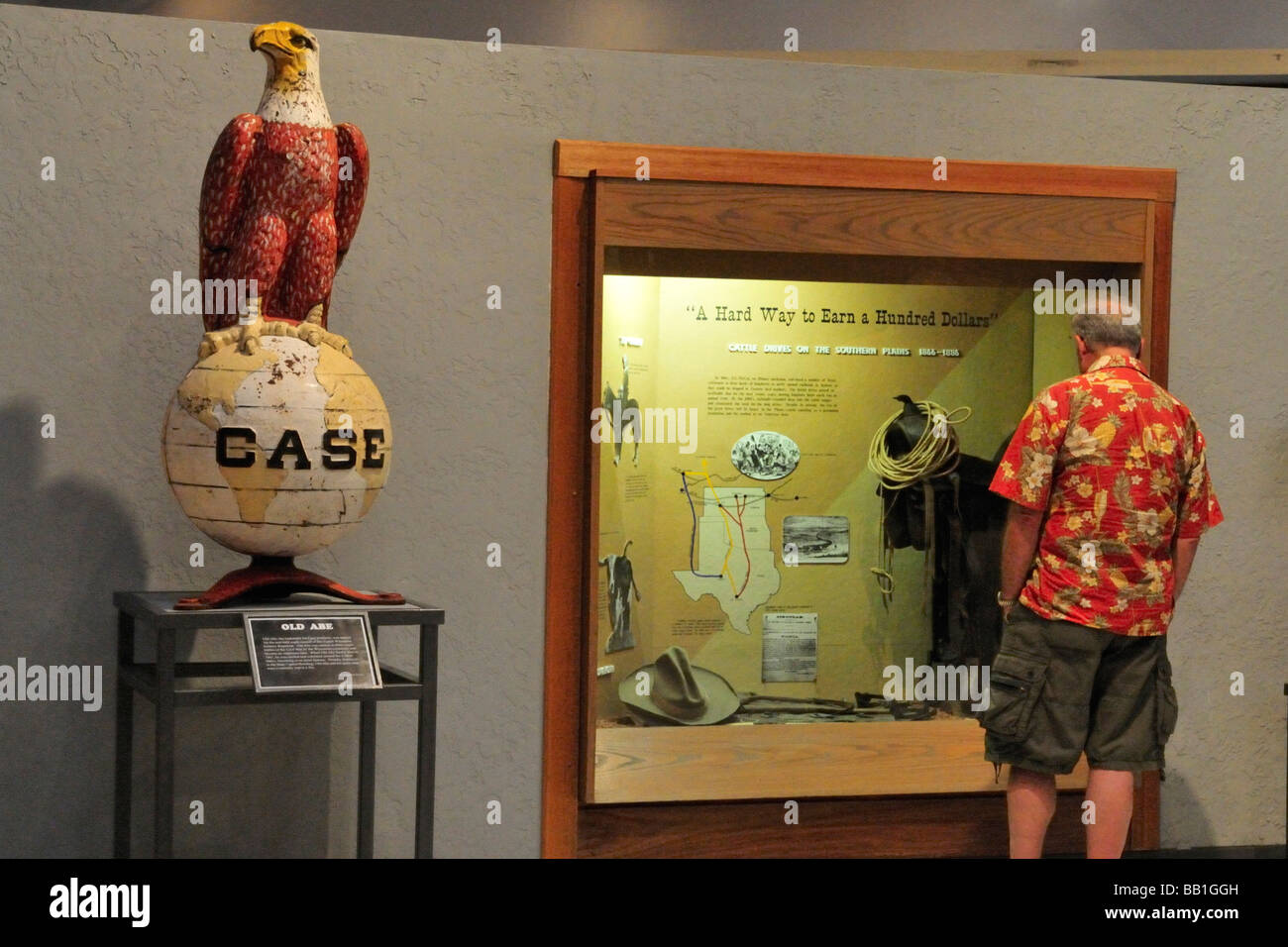 Visitatore nel Museo di Great Plains controlla un display mentre un aquila calva scultura sembra lontano Foto Stock