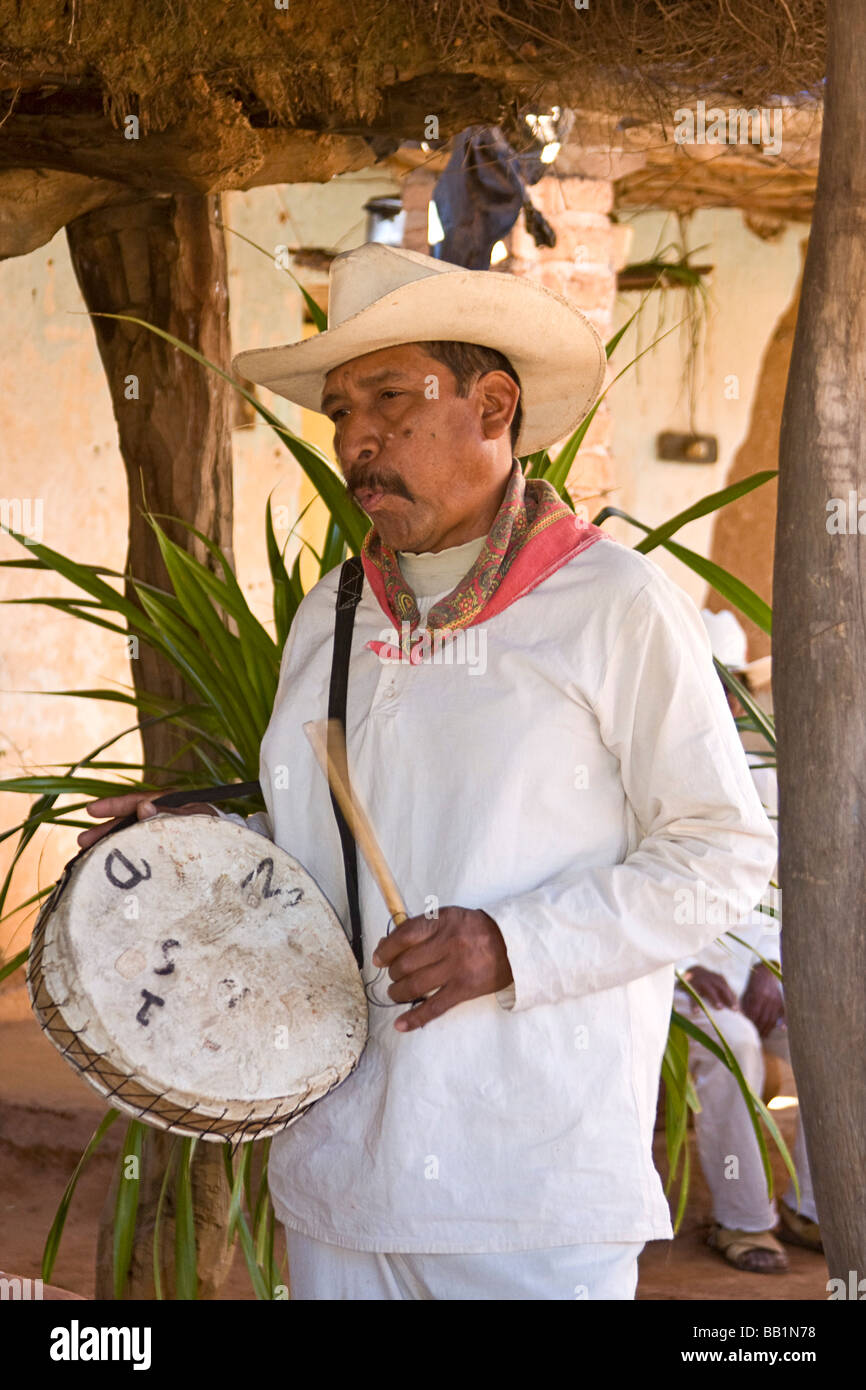 Uomo nativo fischietti mantenendo il ritmo sul tamburo come colleghi nativi di uomo non danza cerimoniale nel villaggio di Mayo Capomos, Messico Foto Stock