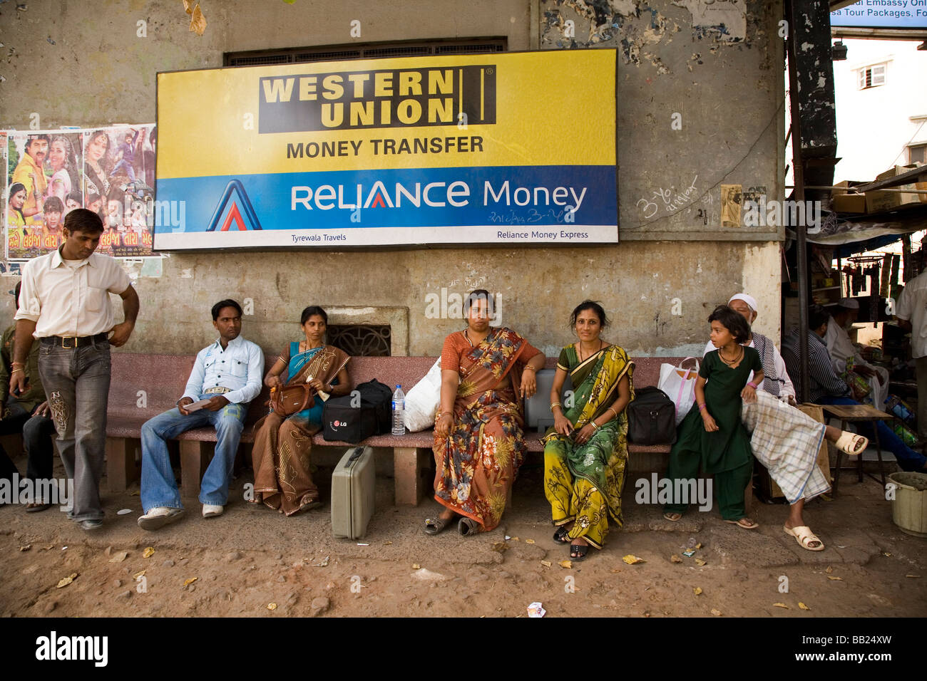 Gli uomini e le donne di attendere per un autobus nella zona centrale di Ahmedabad, Gujarat. Foto Stock