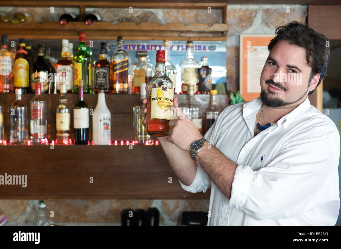 Saba Chris Johnson membro del consiglio isola è di servire un bicchiere di rum nel suo bar ristorante Saba s tesoro Foto Stock