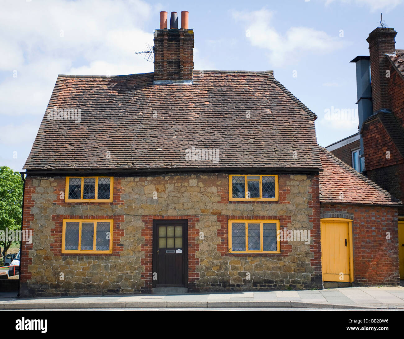 Cottage con verniciatura in giallo (tonalità Gold Cup) che è il Cowdray Station Wagon colore. Midhurst, West Sussex, Regno Unito Foto Stock