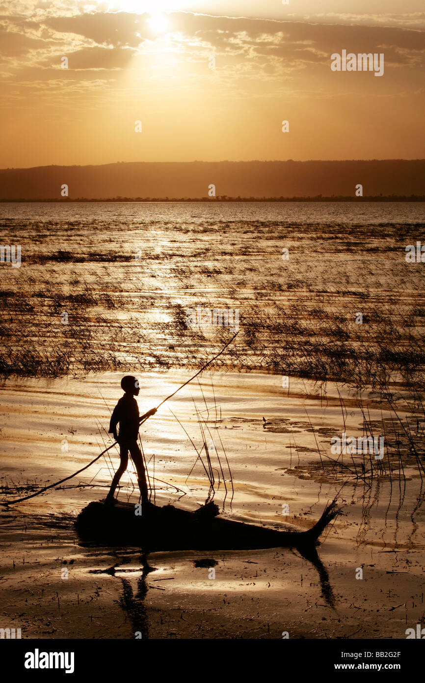 Ragazzo su una lamella di polarizzazione in zattera sul lago di Awasa in Etiopia al tramonto Foto Stock