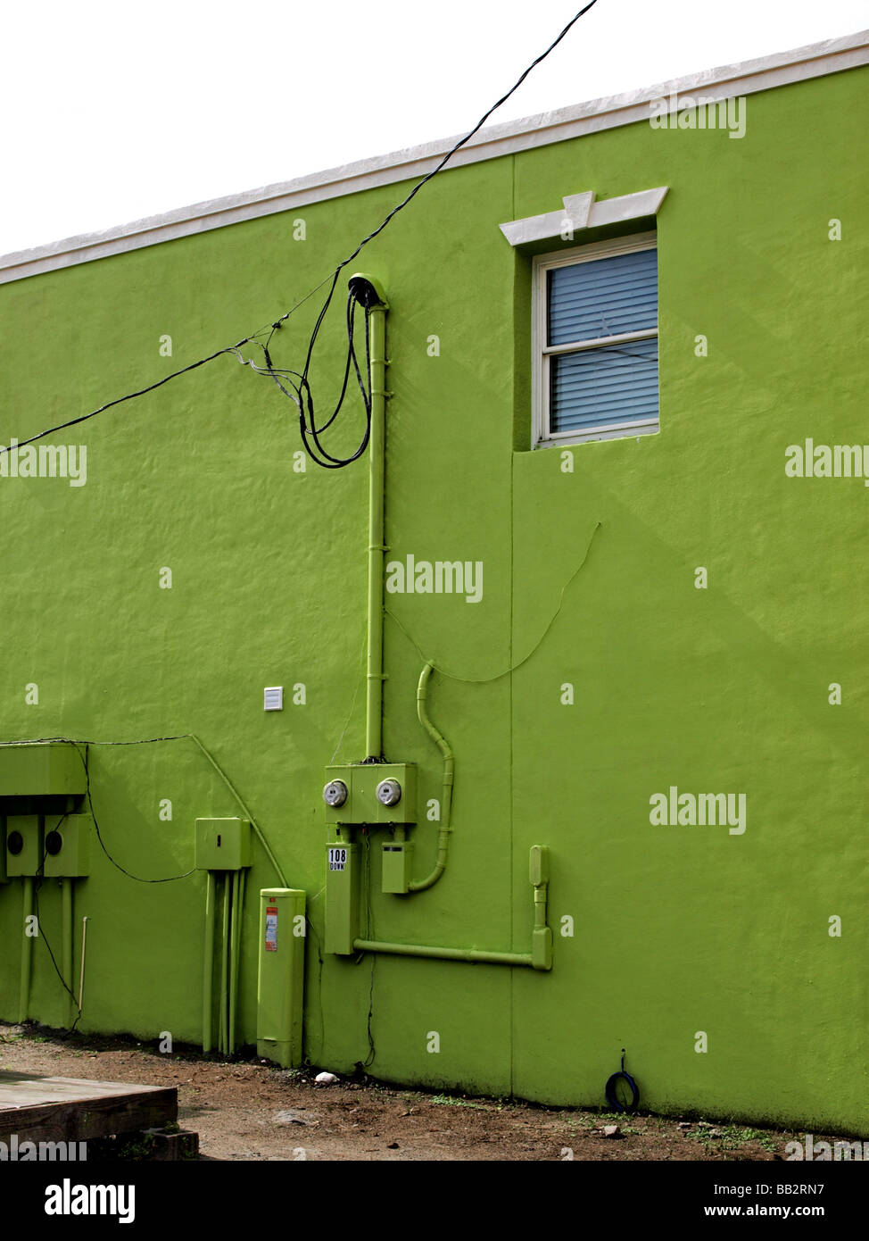 Verde scuro edificio commerciale parete con finestra utilità e le tubazioni di alimentazione e di metri e fili ricco colore colore Foto Stock