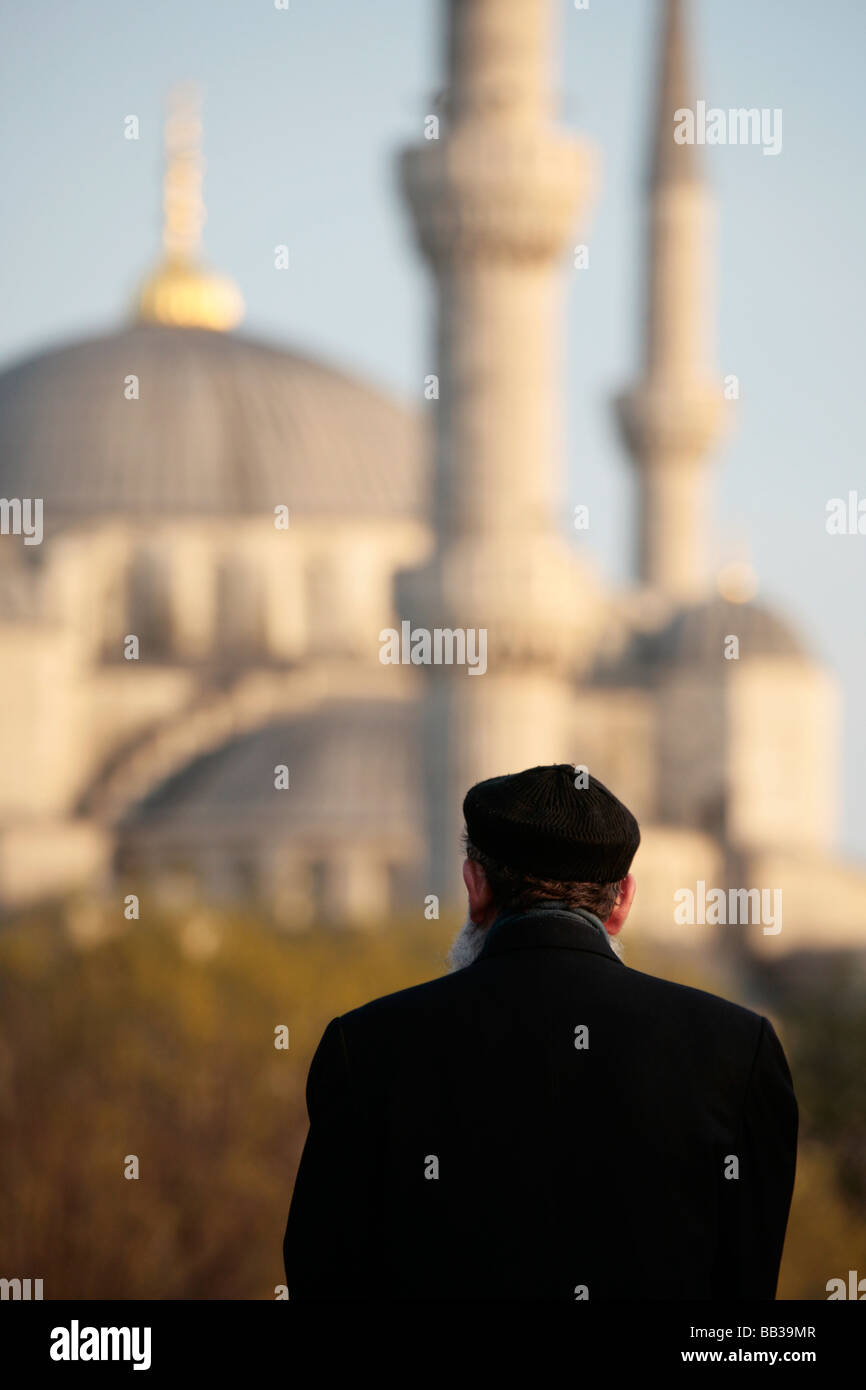 L uomo nel tradizionale abito turco guardando la Moschea Blu di Sultanahmet Istanbul Foto Stock