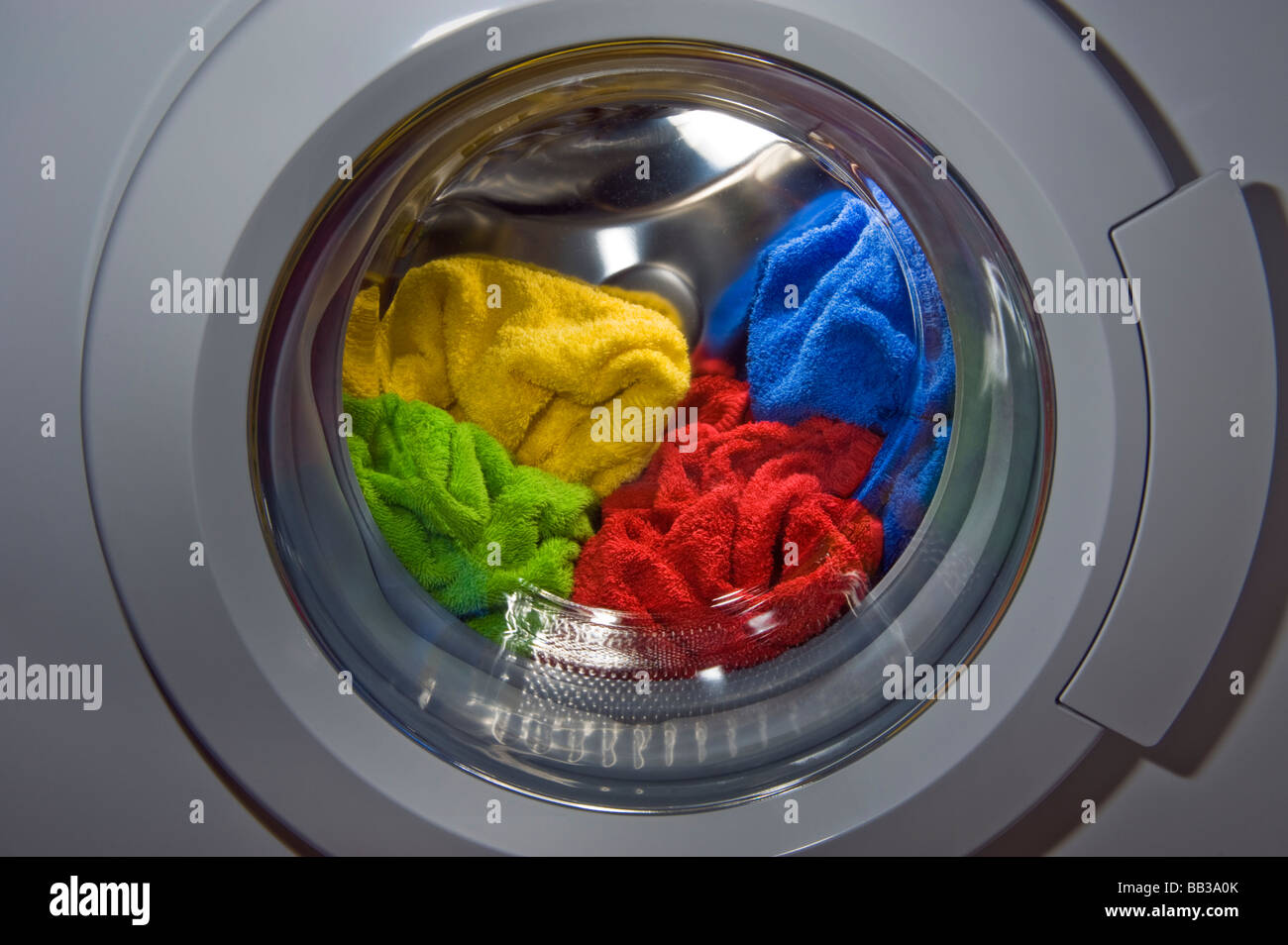 Macchina di lavaggio nel ciclo di lavaggio detergente per la pulizia di indossare vestiti casual panno spugna spugna all'interno di colore colore rosso giallo verde Foto Stock