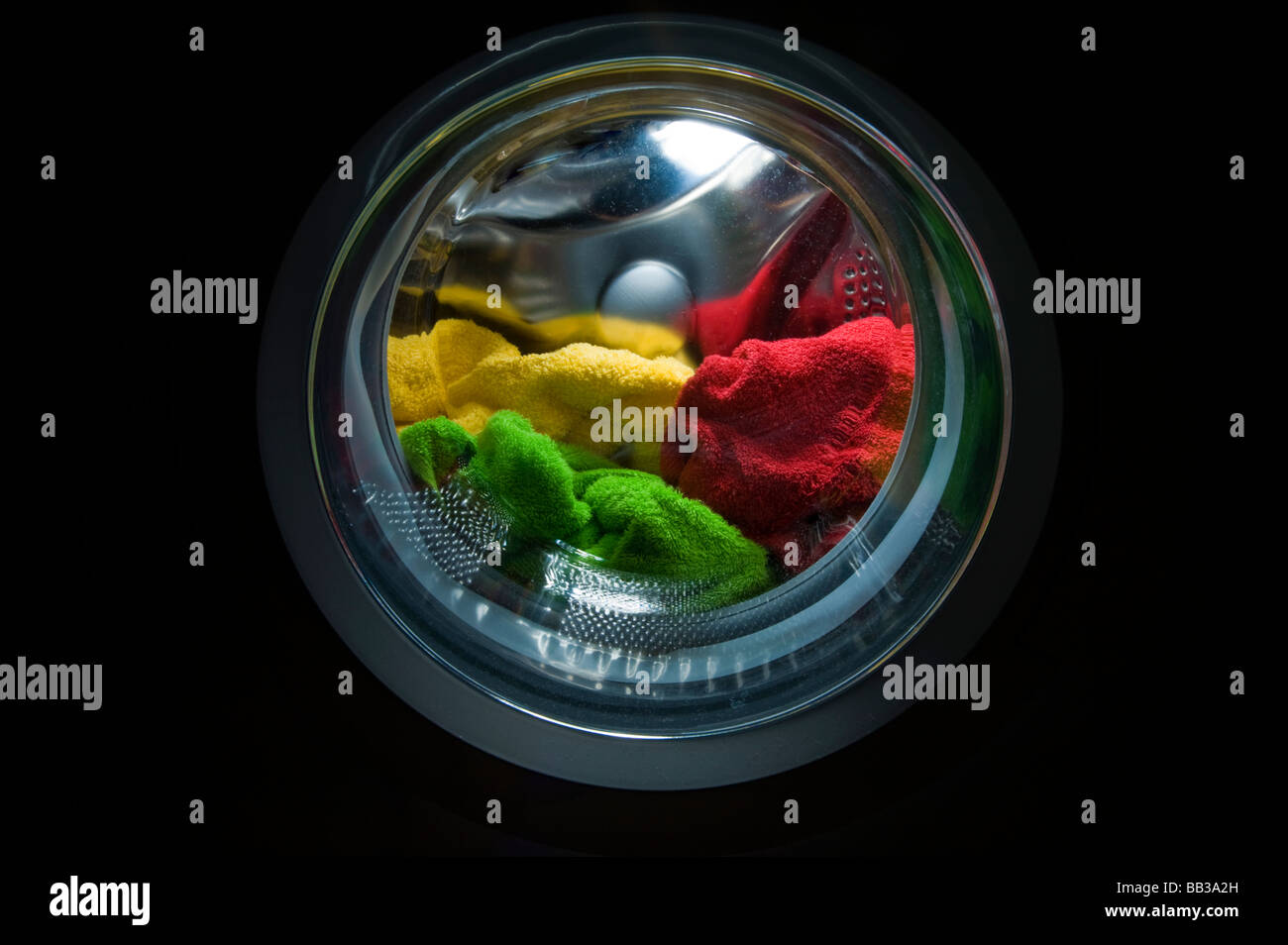 Macchina di lavaggio nel ciclo di lavaggio detergente per la pulizia di indossare vestiti casual panno spugna spugna all'interno di colore colore rosso giallo verde Foto Stock