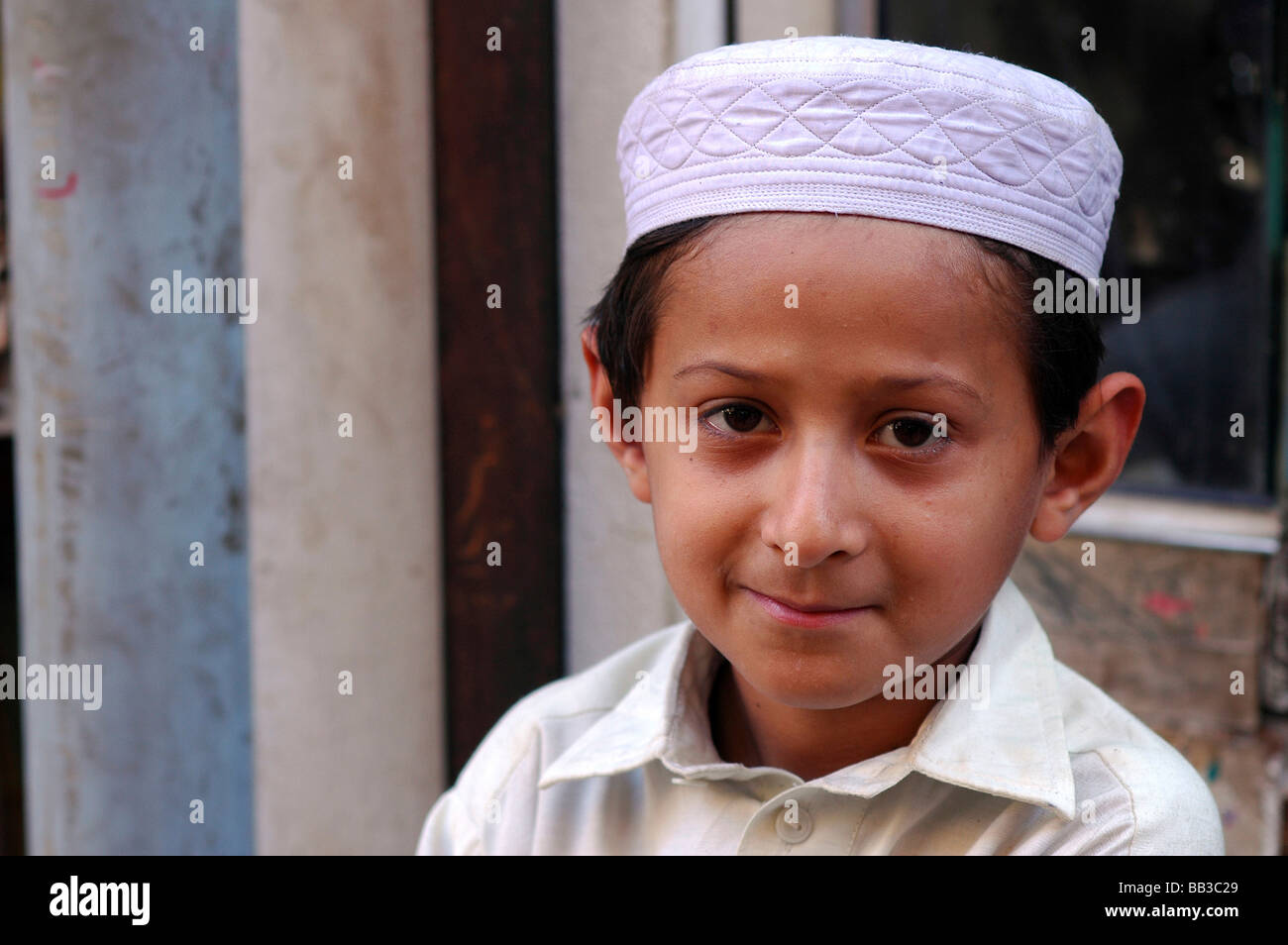 Ritratto di un giovane ragazzo pakistano che indossa il punjabi bianco tuta  e un bianco ricamato cappello musulmano, sorride dolcemente Foto stock -  Alamy