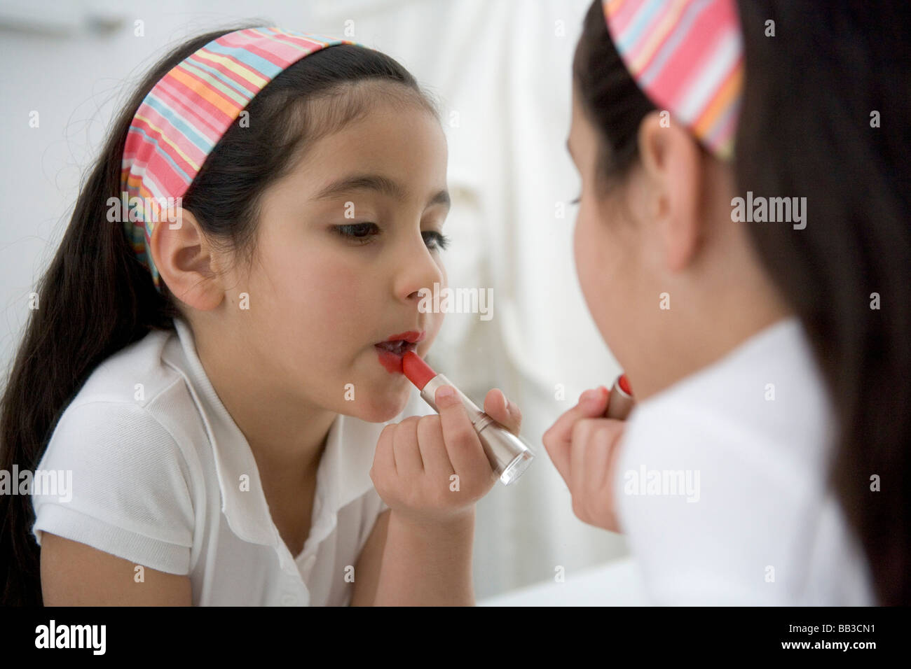 Bambina mettendo il rossetto su Foto stock - Alamy