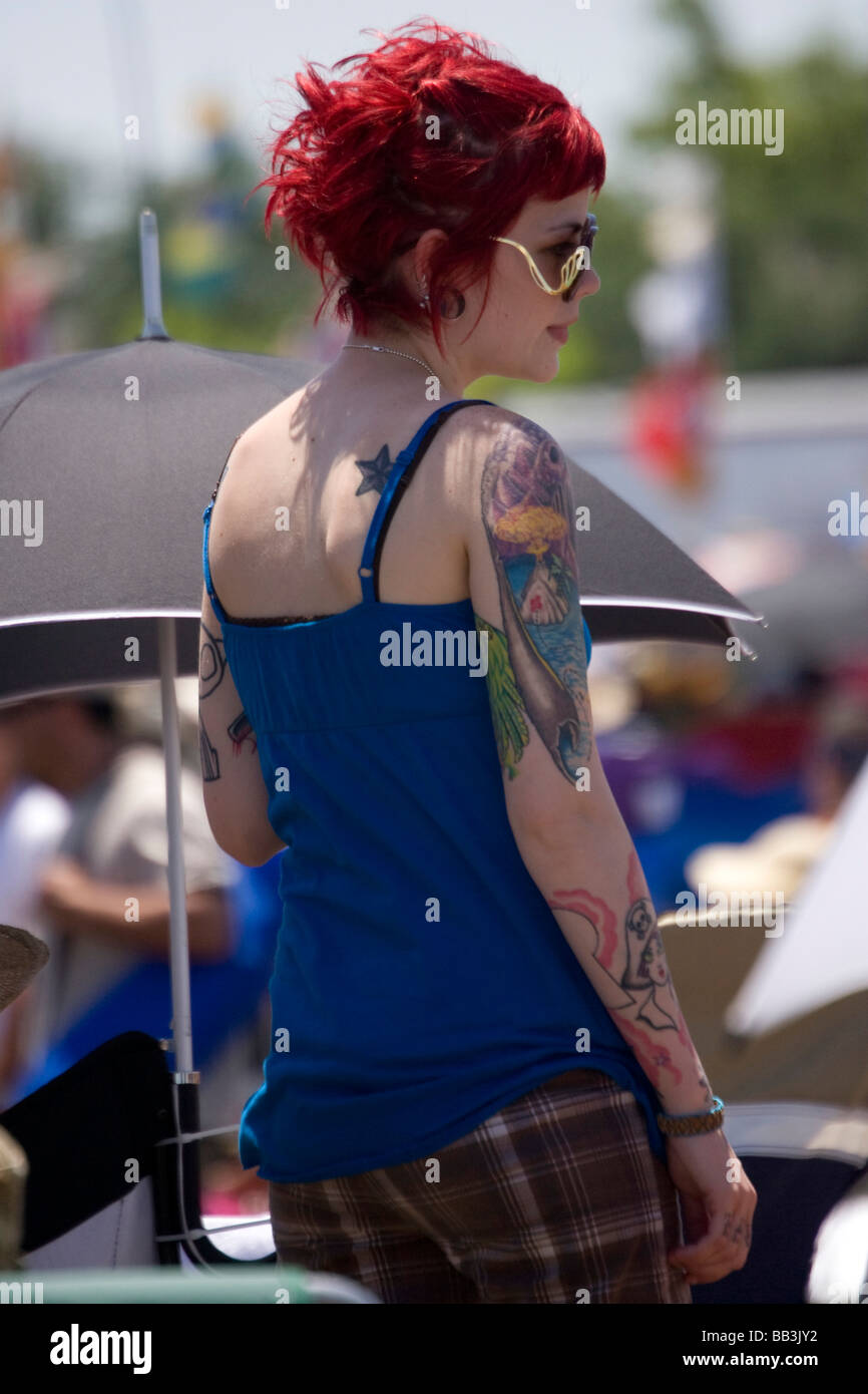 Stati Uniti d'America, Louisiana, New Orleans. Femmina e Jazz Heritage Festival partecipante con i capelli rossi e i tatuaggi. Foto Stock