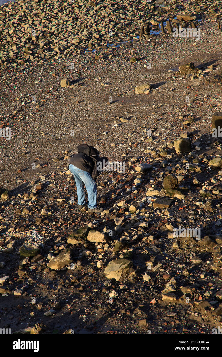 Un uomo cerca il Tamigi Beach a bassa marea vicino a Southwark London REGNO UNITO Foto Stock