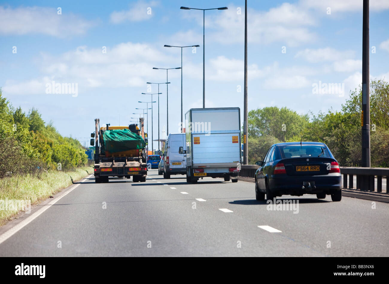 Autovetture e autocarri pesanti in circolazione sulla A63 percorso una strada a doppia carreggiata in direzione est verso Hull, England, Regno Unito Foto Stock