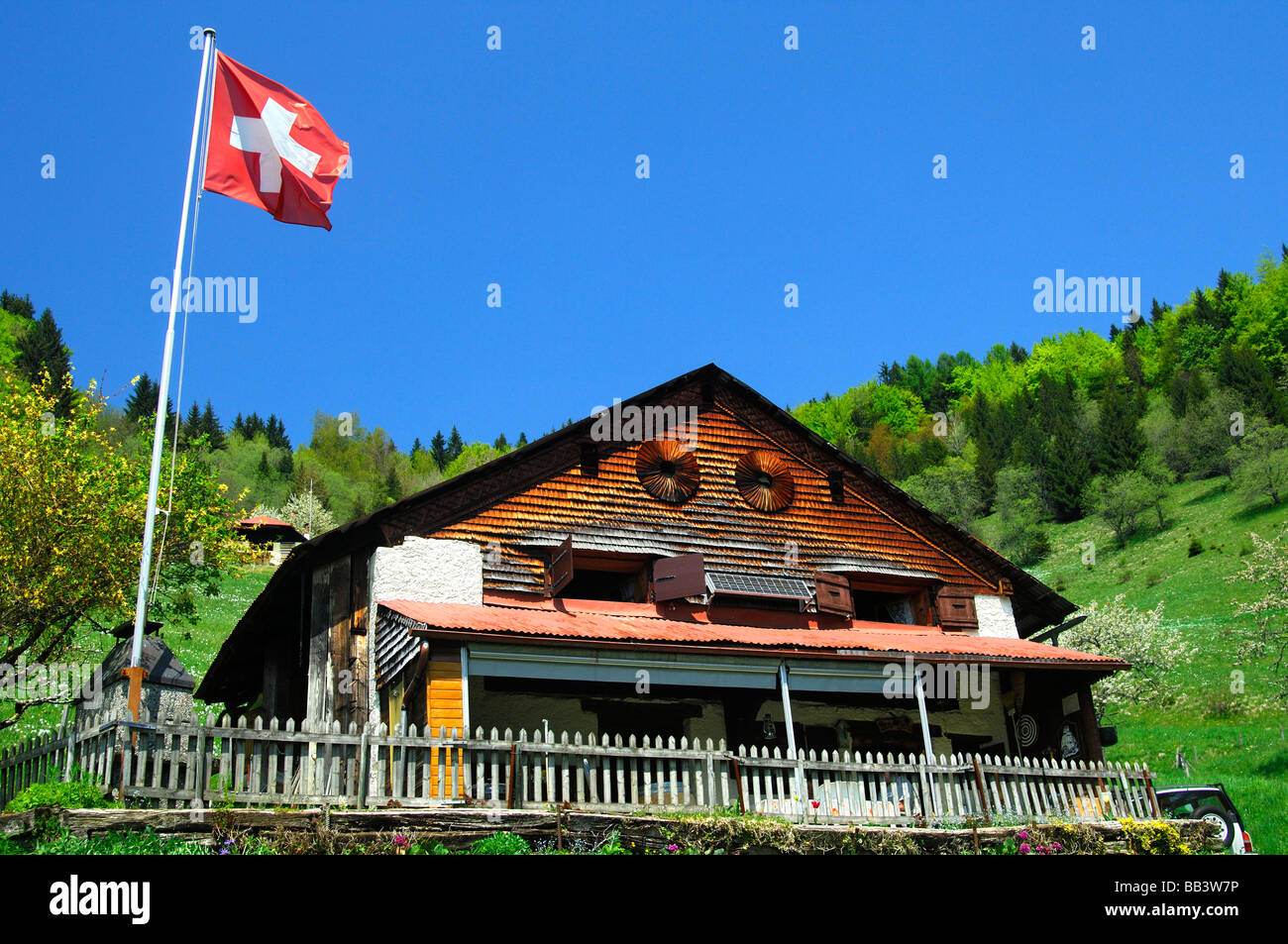 Chalet con la bandiera svizzera a Les Avants vicino a Montreux, Svizzera Foto Stock