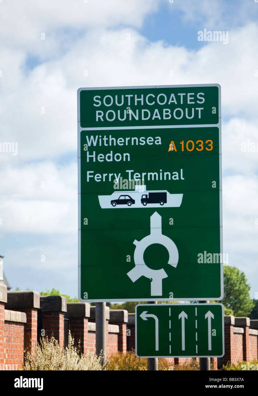 Un verde cartelli stradali con la rotatoria incrocio di informazioni e consigli di corsia England Regno Unito Foto Stock
