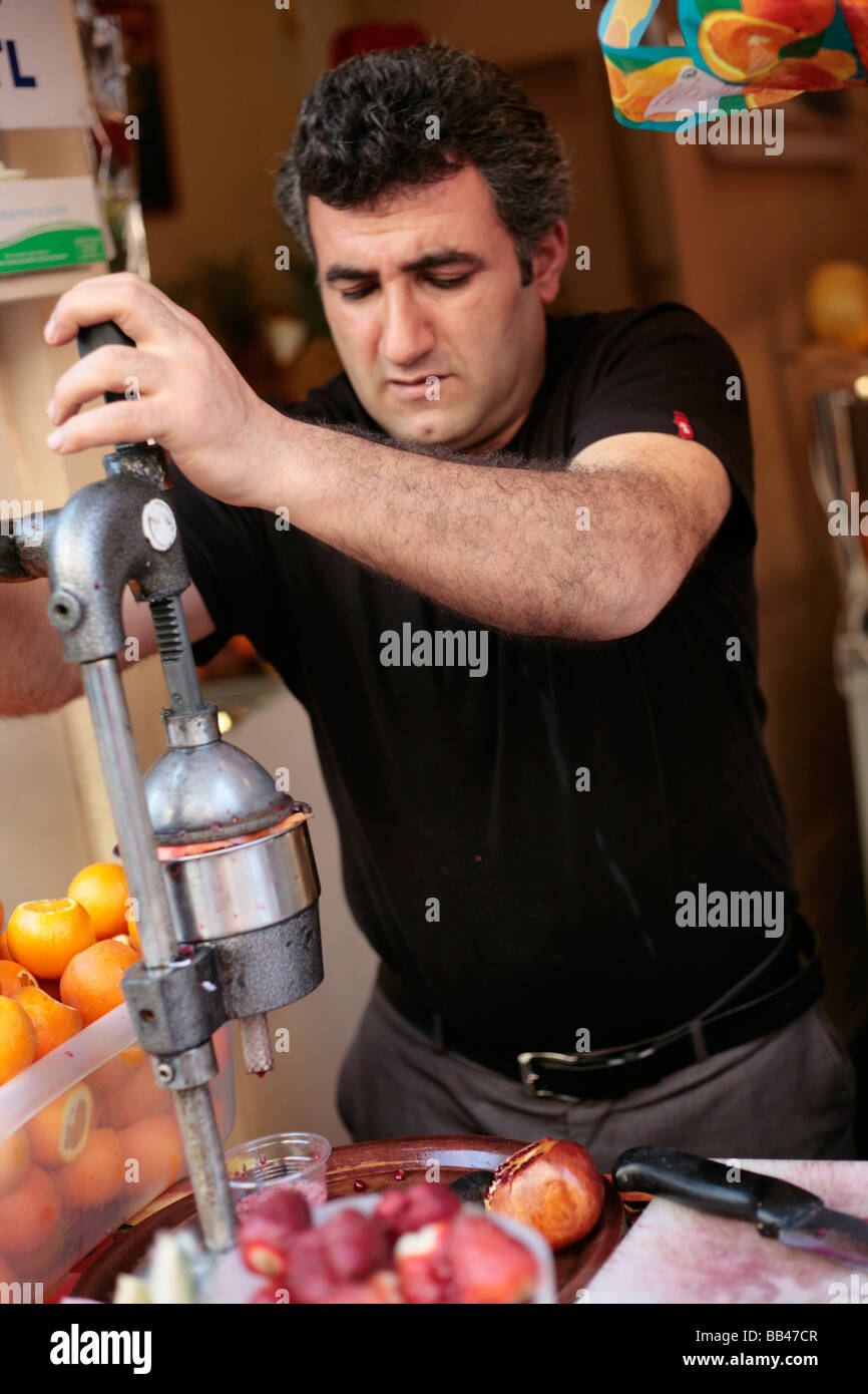 L'uomo spremendo il succo di melograno in Galata Istanbul Foto Stock