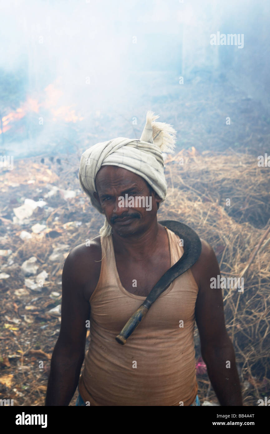 Un uomo bruciare rifiuti, Fort Cochin, India. Foto Stock