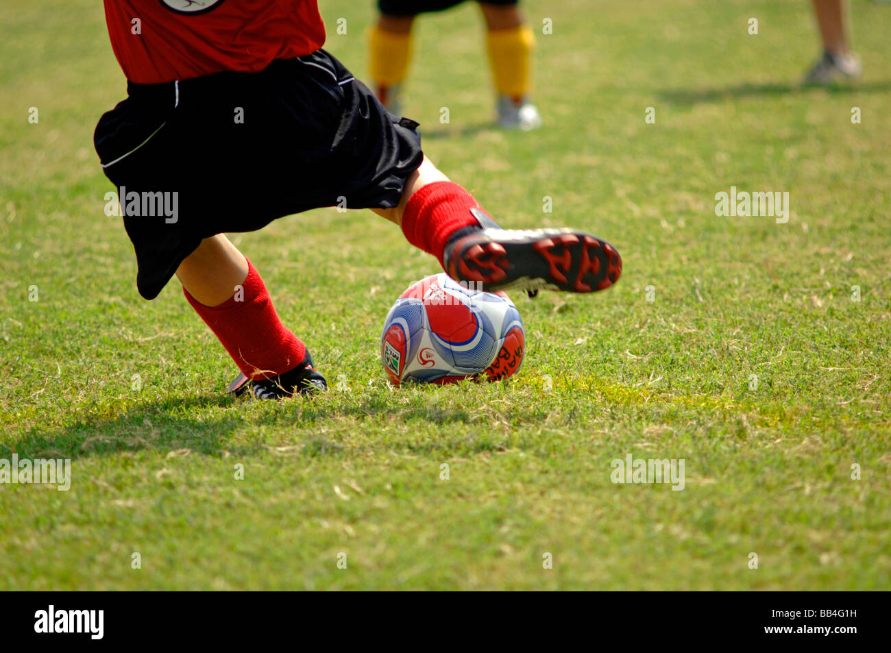 Gli uomini adulti, ragazzi, ragazze eseguire, play, stand e kick utilizzando confortevoli piede appropriato indossare per la loro attività atletiche Foto Stock