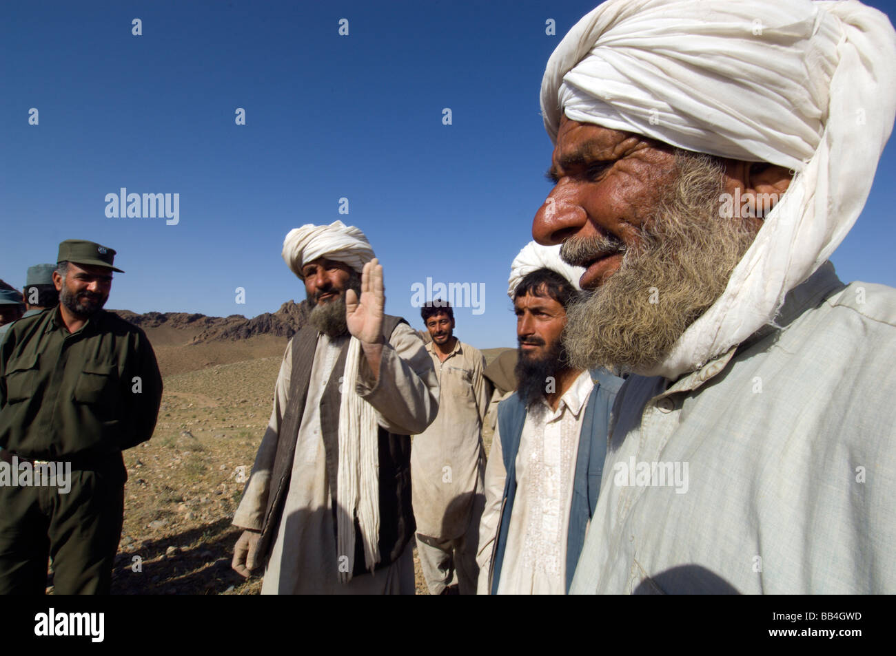 Poliziotti di parlare per le popolazioni nomadi Pashtun herders vicino il loro accampamento presso la base del Dau Shakh gamma, al di fuori della città di Gurian, Herat Foto Stock