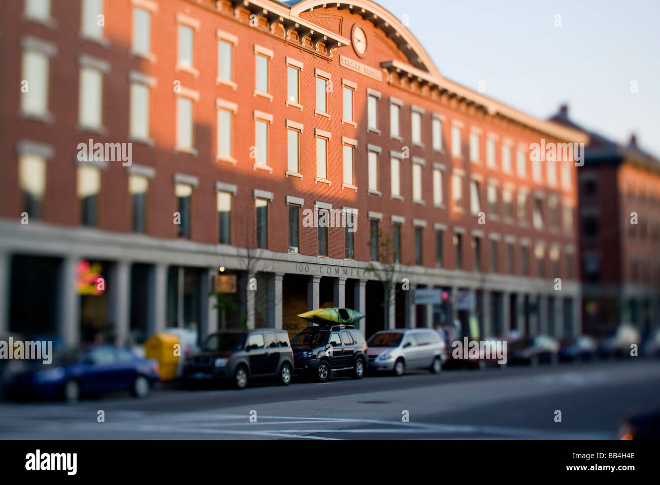 Una fila di automobili parcheggiate sedersi davanti a un edificio per uffici a Portland, Maine. Foto Stock