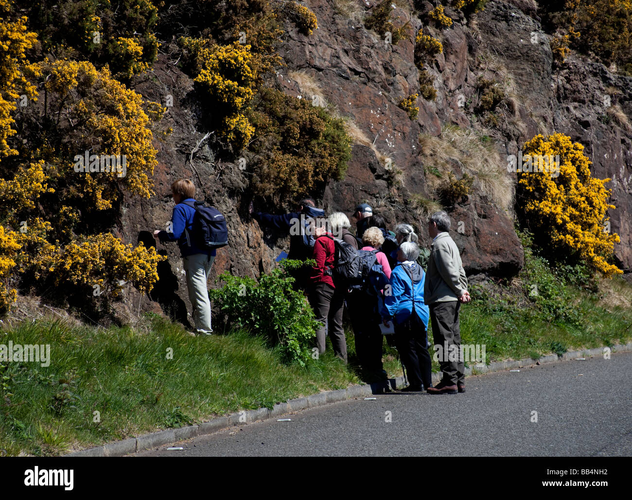 Maschio e femmina su una geologia tour a piedi attraverso il Parco Holyrood, Edimburgo, Scozia, Regno Unito, Europa Foto Stock