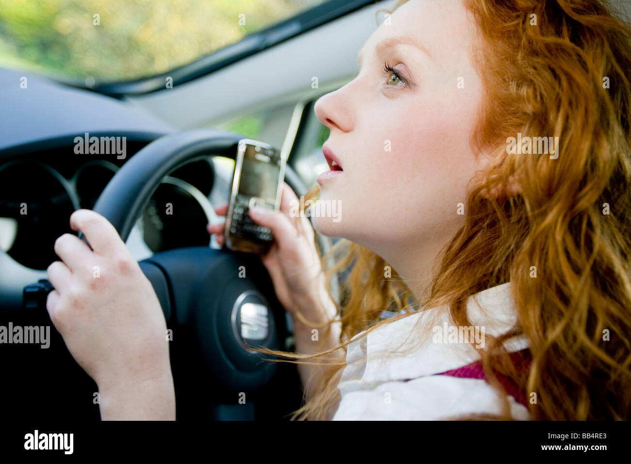 Ragazza texting durante la guida Foto Stock